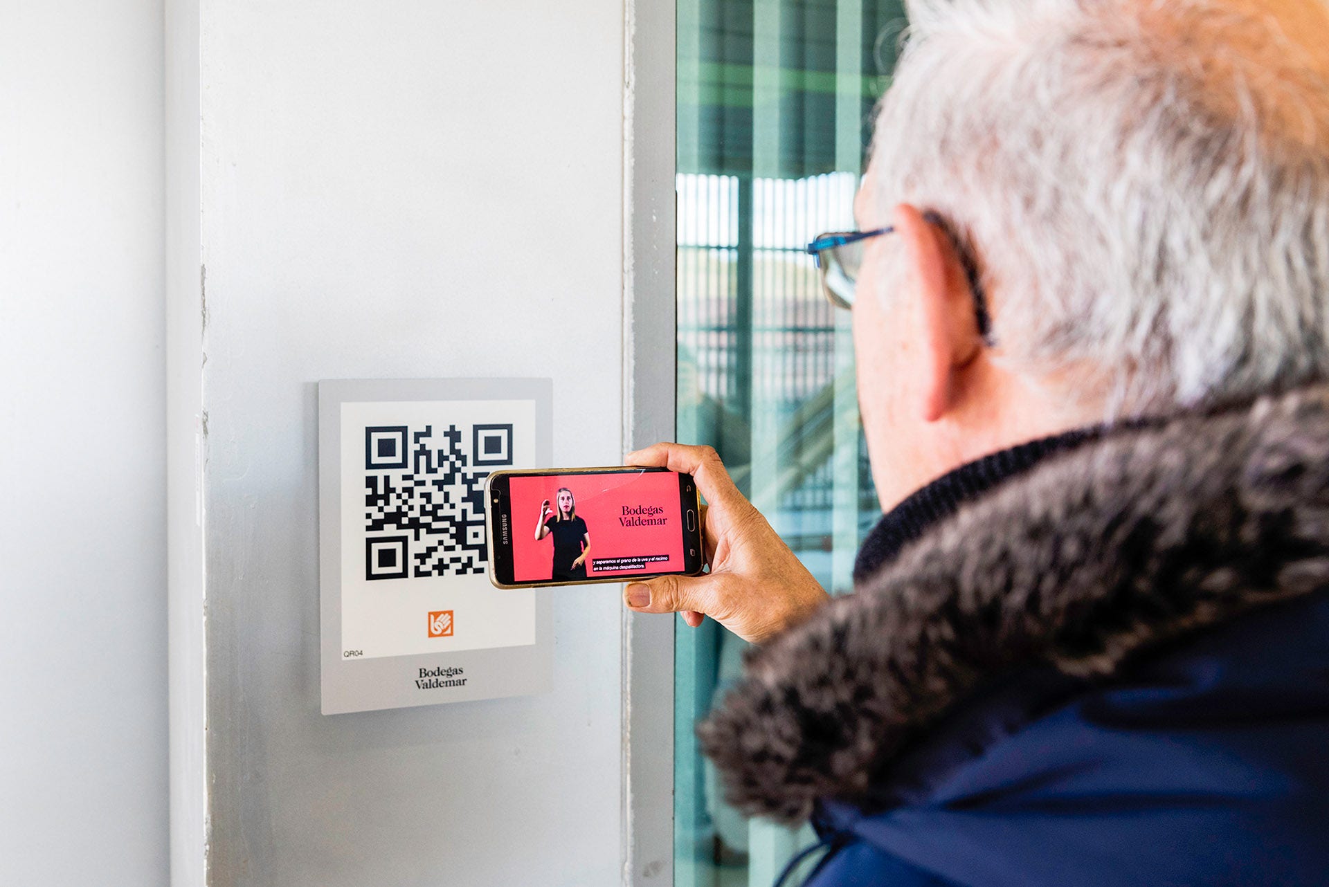A man scanning a QR code with his phone at a winery