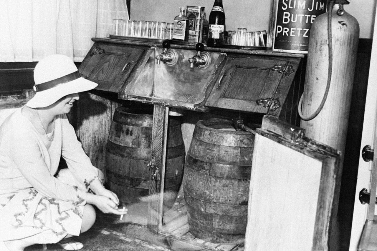 Woman changing wooden kegs of beer in New York speakeasy