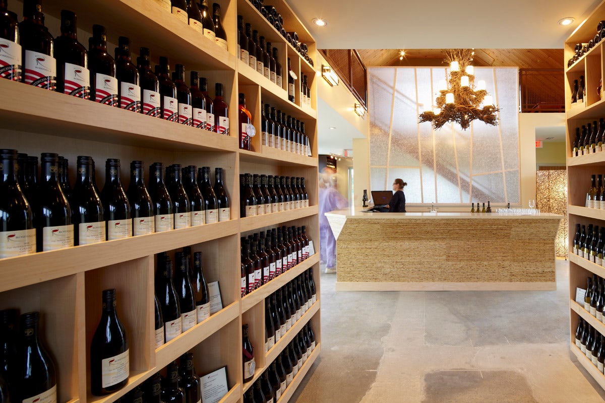 Shelves of wines down a hallway leadoing to a modern bar